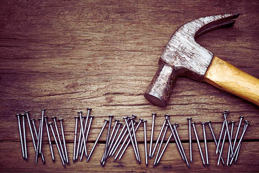 Hammer und Nägel auf Holzplatte