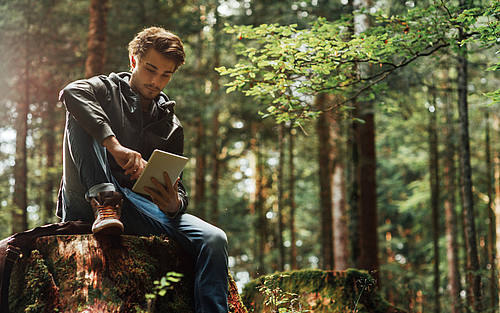 Junger Mann surft im Wald