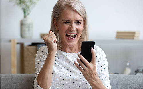 Ältere Frau spielt am Smartphone