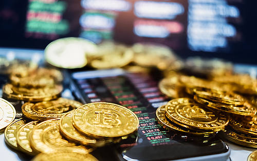 Goldene Bitcoin-Münzen auf einem Smartphone
