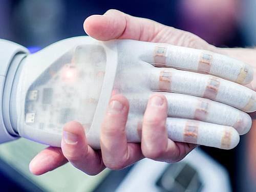 Handschlag mit einem bionischen Roboter. 42 Staaten haben sich auf erste Grundsätze für den Umgang mit künstlicher Intelligenz verständigt. Foto: Hauke-Christian Dittrich/Archiv