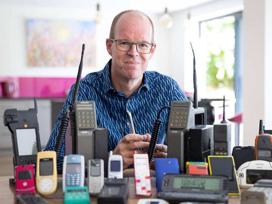 Ben Wood, Gründer des Museums, sitzt hinter einigen der über 2.000 einzigartigen Mobiltelefone, die jetzt Teil des Online-Museums sind. Foto: Mobile Phone Museum/Vodafone/PA Media/dpa/Archiv