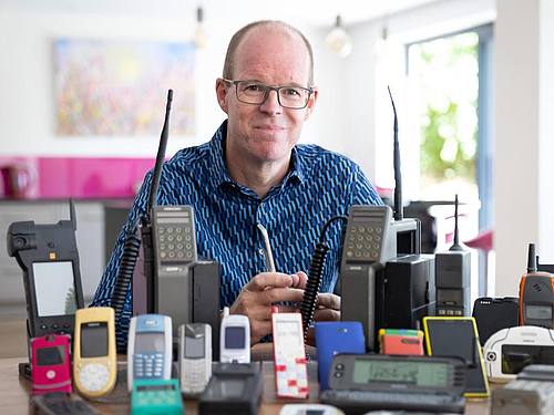 Ben Wood, Gründer des Museums, sitzt hinter einigen der über 2.000 einzigartigen Mobiltelefone, die jetzt Teil des Online-Museums sind. Foto: Mobile Phone Museum/Vodafone/PA Media/dpa/Archiv