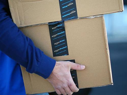 Amazon-Pakete in den Armen einen Lieferanten