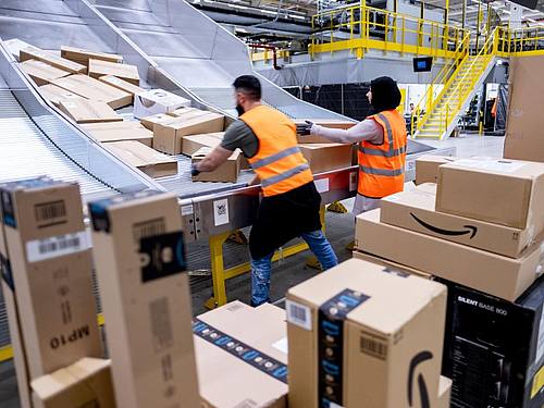 Mitarbeiter des Paketversenders Amazon sortieren Pakete im Sortierzentrum in Garbsen. Foto: Peter Steffen