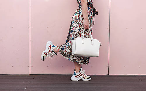 Frau in Kleid und Turnschuhen