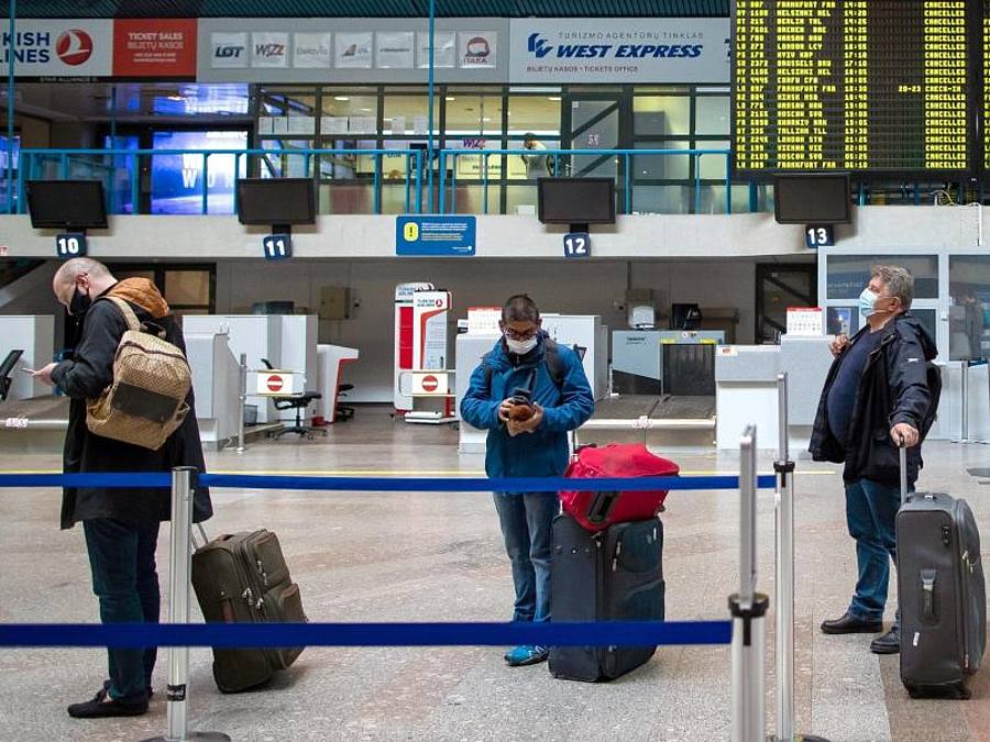Passagiere mit Smartphones in einer Schlange im Internationalen Flughafen von Vilnius. Foto: Mindaugas Kulbis/AP/dpa