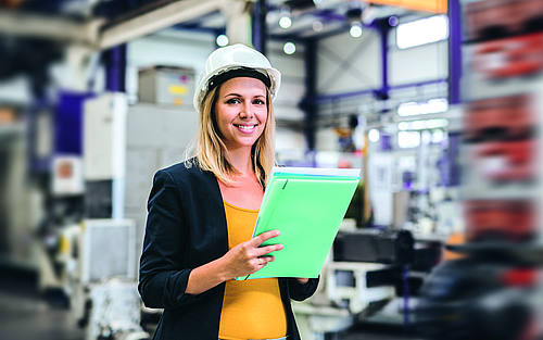 Frau mit Helm und Projektakte